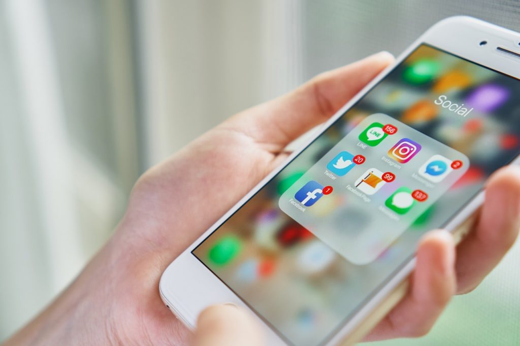 A person holding a phone with their apps