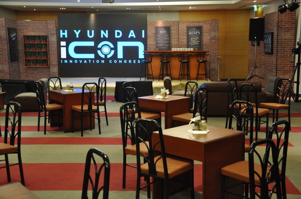 An event with tables and chairs arranged to face the stage