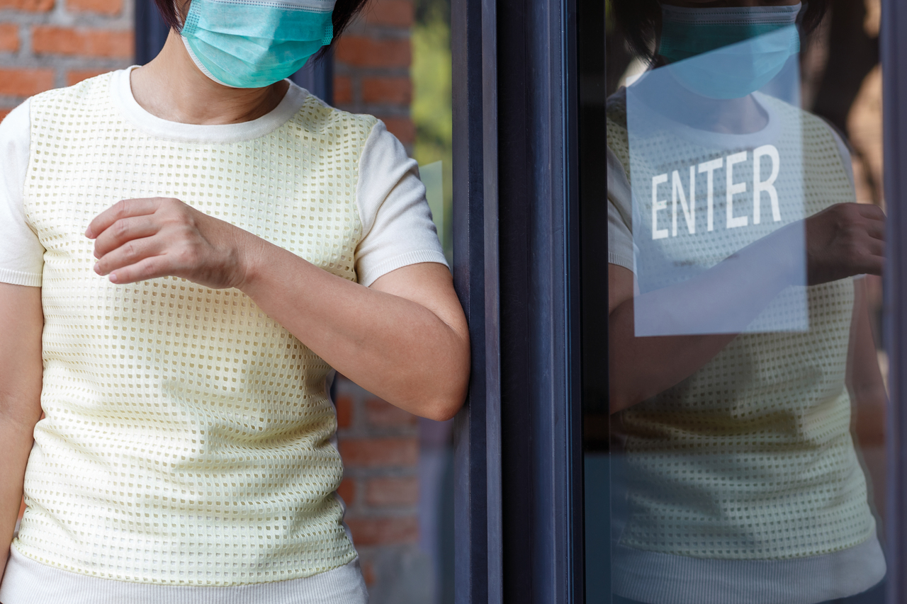 A person entering a building with a face mask on