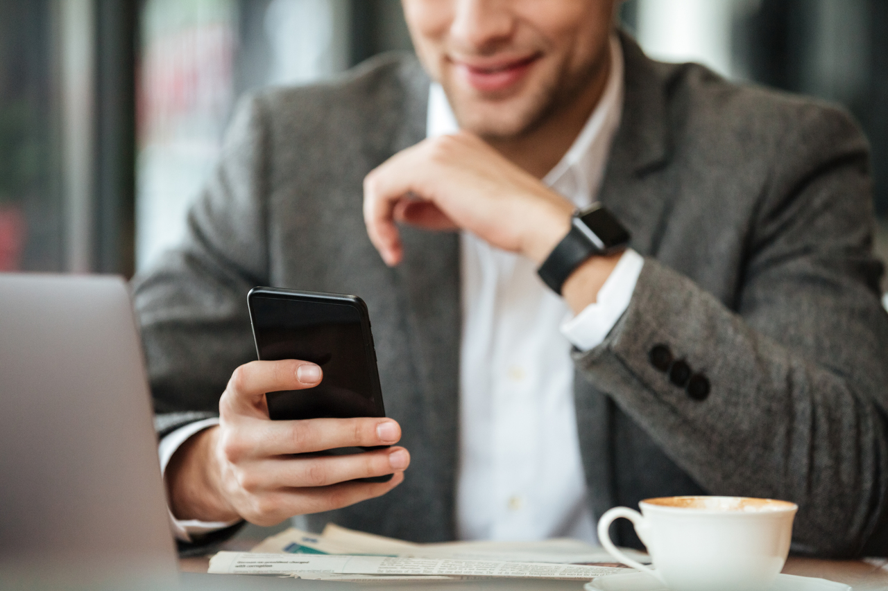 A man smiling at his phone