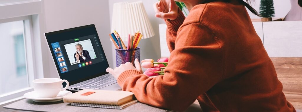 Close up of a person watching a guest speaker at an online event